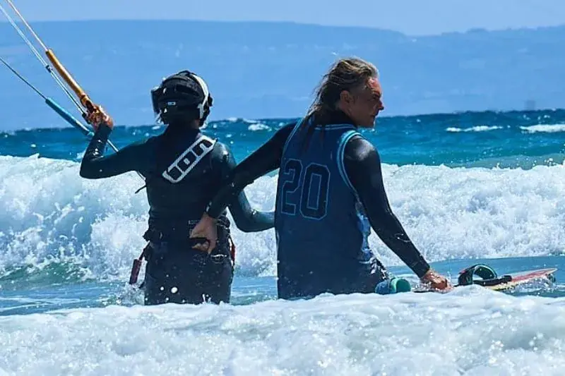 Manuel explicando una maniobra a un alumno en la playa